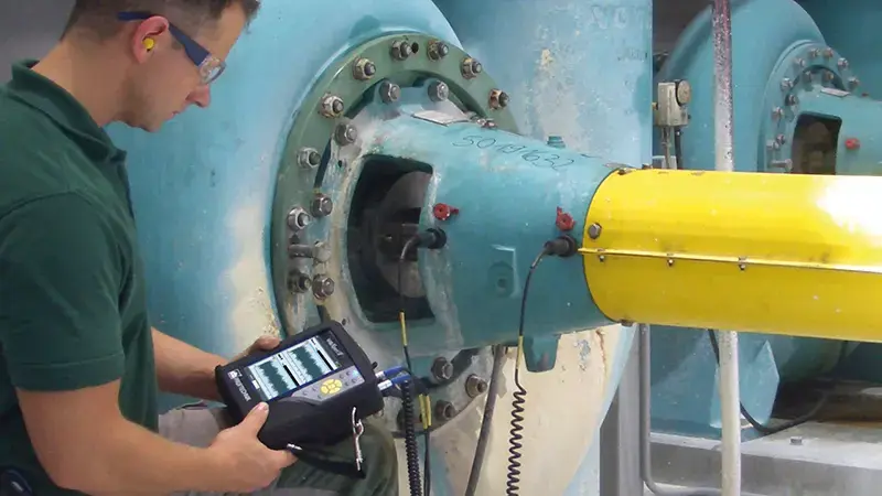 Worker using the VIBXPERT II on motor